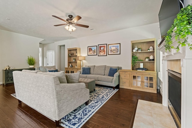 13115 Parkbrook Way Ln, Sugar Land, TX 77498 - living room featuring a fireplace, hardwood / wood-style floors, a ceiling fan, built in features, and baseboards