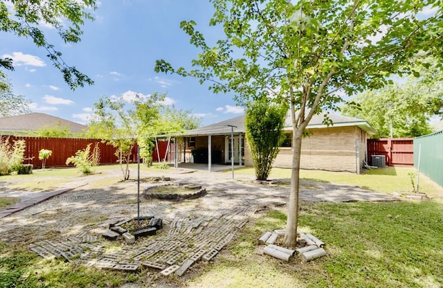back of property featuring a fenced backyard, a yard, cooling unit, a patio area, and brick siding