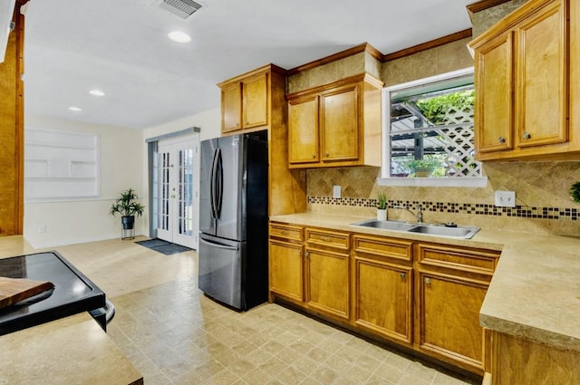 kitchen with light floors, light countertops, visible vents, a sink, and freestanding refrigerator