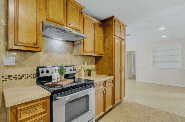kitchen featuring under cabinet range hood, light floors, light countertops, electric stove, and decorative backsplash