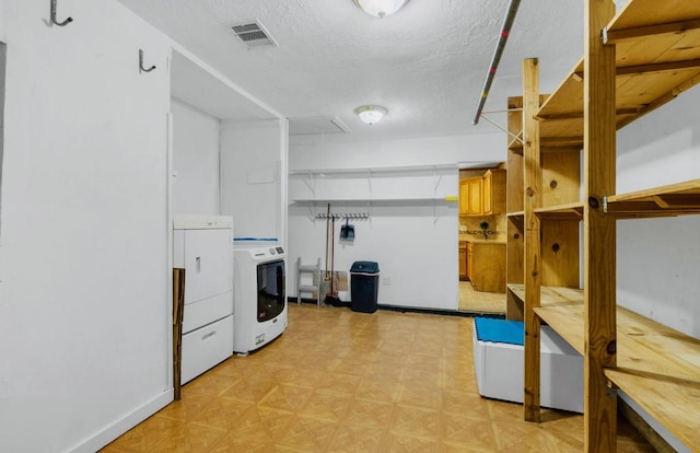 washroom featuring washer / dryer, visible vents, a textured ceiling, and laundry area