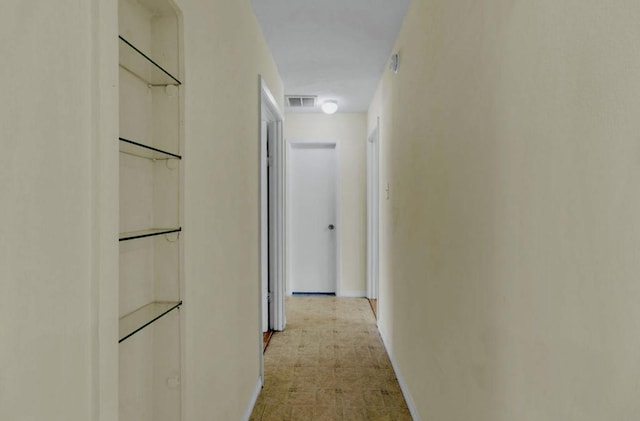 corridor with baseboards and visible vents