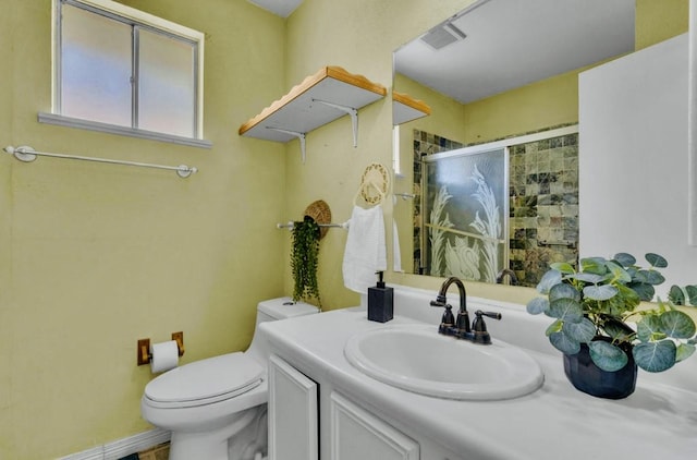 full bath featuring toilet, vanity, and a stall shower
