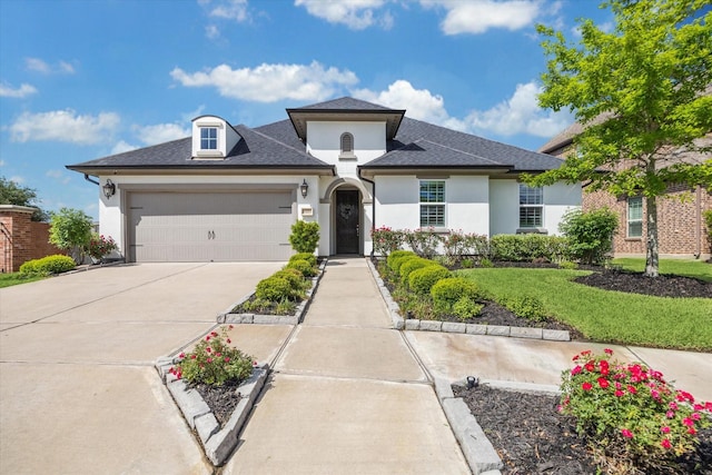 view of front of property featuring stucco siding, a front lawn, concrete driveway, and a garage