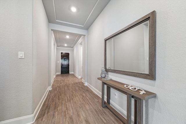 corridor with attic access, baseboards, wood finished floors, and recessed lighting