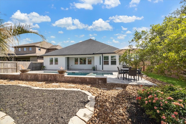 rear view of property with a fenced in pool, a fenced backyard, a patio, and an in ground hot tub