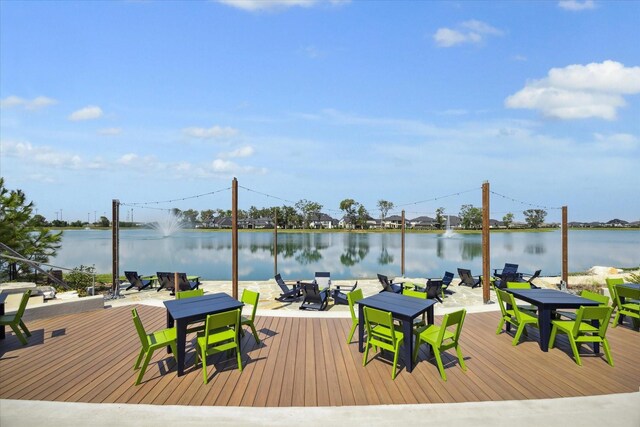 view of dock featuring outdoor dining area and a water view