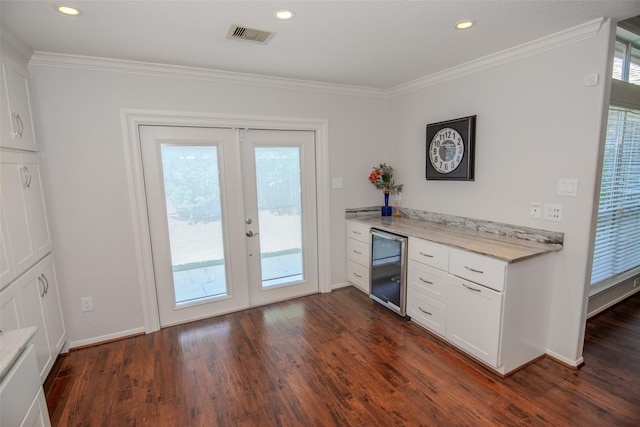 kitchen with wine cooler, ornamental molding, french doors, dark wood-type flooring, and white cabinetry