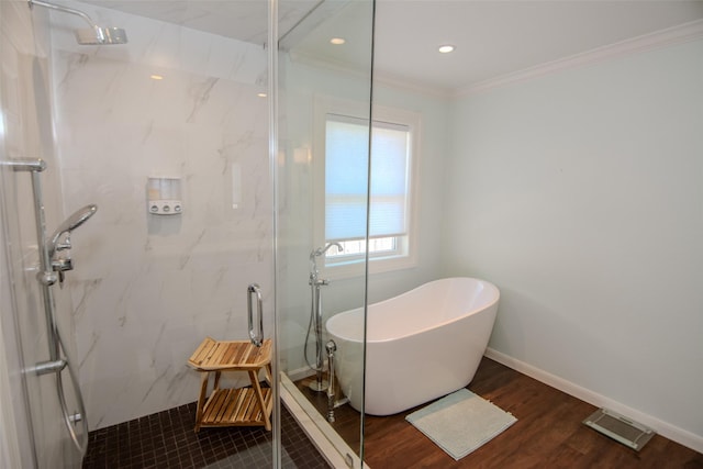 bathroom featuring wood finished floors, a marble finish shower, a soaking tub, ornamental molding, and visible vents
