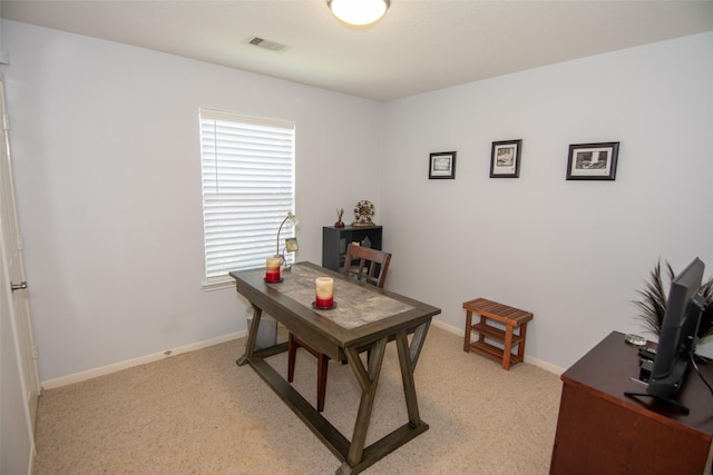 office area with baseboards, visible vents, and light colored carpet