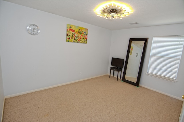 empty room with light carpet, visible vents, and baseboards
