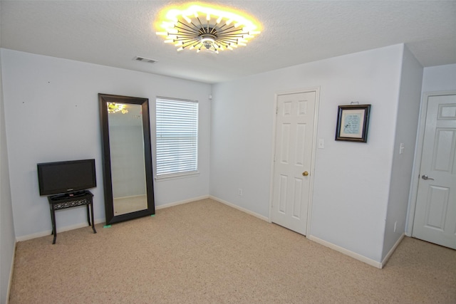 spare room featuring carpet floors, visible vents, and baseboards
