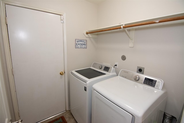 clothes washing area featuring separate washer and dryer and laundry area
