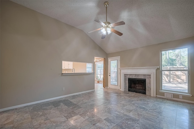 unfurnished living room with a textured ceiling, ceiling fan, and a healthy amount of sunlight