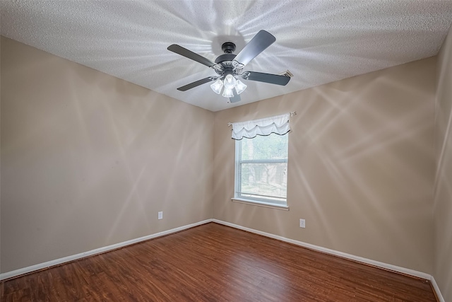 unfurnished room with ceiling fan, baseboards, wood finished floors, and a textured ceiling