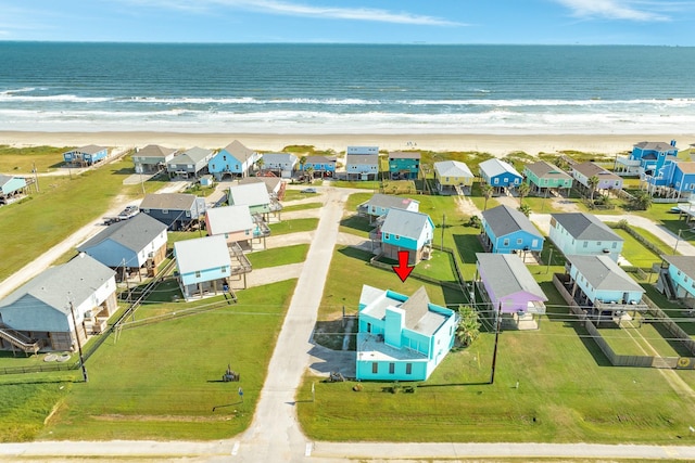 aerial view with a residential view, a view of the beach, and a water view