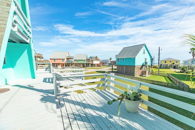 wooden terrace with a residential view, fence private yard, and a lawn