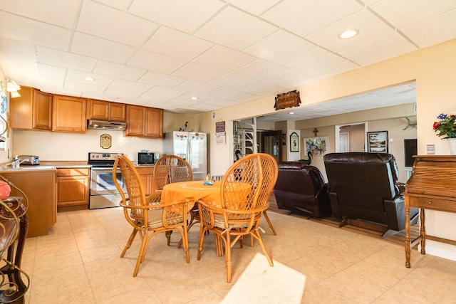 dining space with light tile patterned flooring, a drop ceiling, and recessed lighting