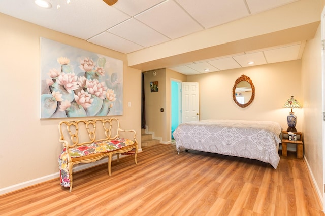 bedroom featuring recessed lighting, baseboards, light wood finished floors, and a paneled ceiling