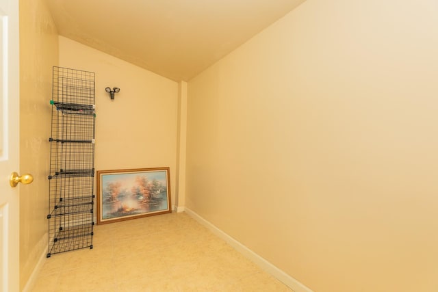interior space with vaulted ceiling and baseboards