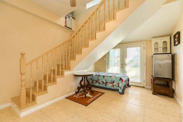 stairway with tile patterned floors, baseboards, and french doors