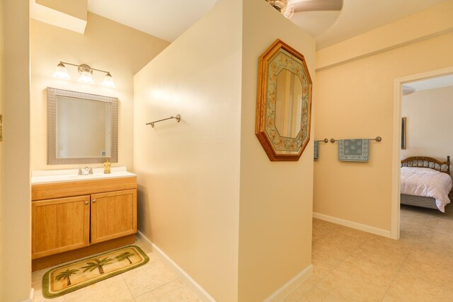 ensuite bathroom with baseboards, tile patterned floors, vanity, and connected bathroom
