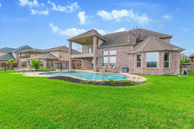 rear view of property with a balcony, a lawn, outdoor lounge area, a fenced backyard, and brick siding