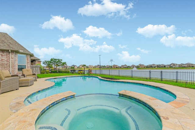 view of swimming pool with fence, a pool with connected hot tub, and a residential view