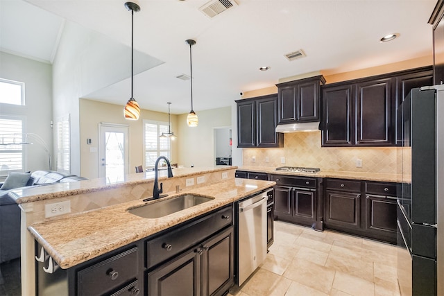 kitchen featuring stainless steel appliances, a sink, visible vents, decorative backsplash, and under cabinet range hood