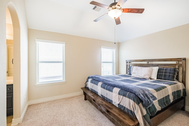 carpeted bedroom featuring a ceiling fan, arched walkways, baseboards, lofted ceiling, and visible vents