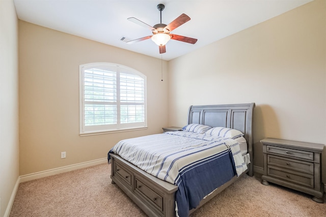 bedroom with light colored carpet, ceiling fan, and baseboards
