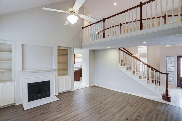 3126 Pebble Bay Dr, League City, TX 77573 - unfurnished living room featuring baseboards, a healthy amount of sunlight, wood finished floors, and a towering ceiling