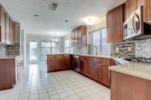 3126 Pebble Bay Dr, League City, TX 77573 - kitchen featuring backsplash, visible vents, a sink, a peninsula, and appliances with stainless steel finishes
