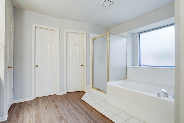 3126 Pebble Bay Dr, League City, TX 77573 - full bath featuring a bath, baseboards, wood finished floors, and a stall shower