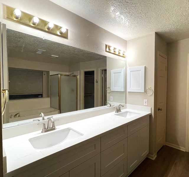 3126 Pebble Bay Dr, League City, TX 77573 - bathroom with wood finished floors, a textured ceiling, a stall shower, and a sink