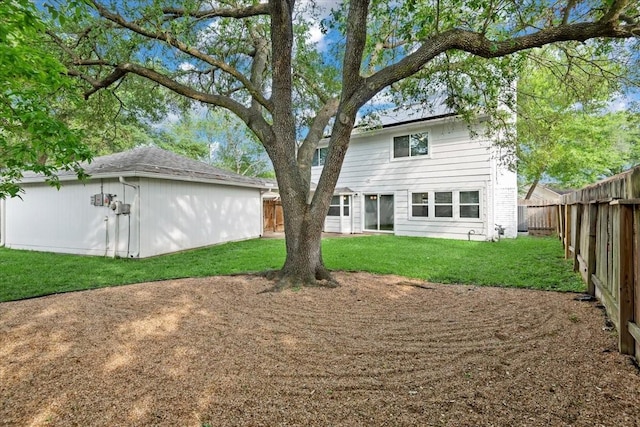 back of house featuring a lawn and a fenced backyard