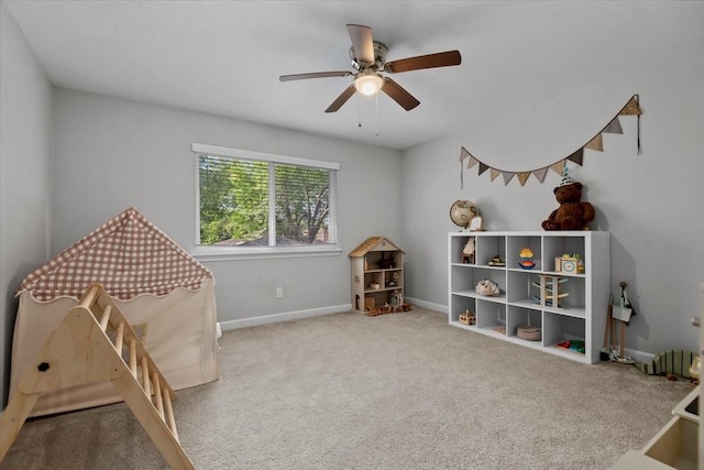 recreation room featuring carpet, a ceiling fan, and baseboards