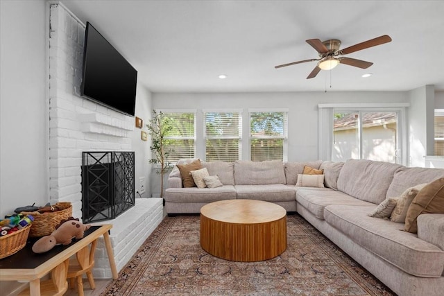 living room with wood finished floors, a brick fireplace, recessed lighting, and ceiling fan
