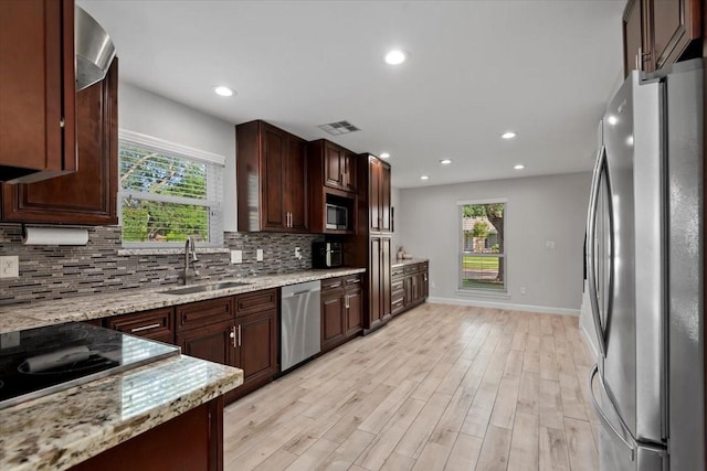 kitchen featuring stainless steel appliances, visible vents, a sink, and backsplash