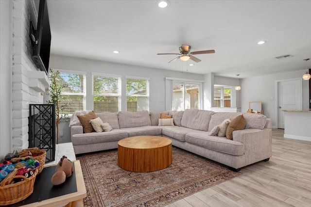 living room featuring recessed lighting, a ceiling fan, visible vents, and light wood-style flooring