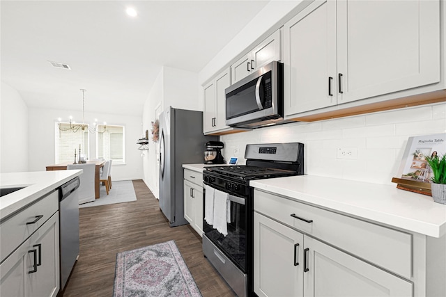 24343 Elmwood Falls Dr, Spring, TX 77373 - kitchen featuring stainless steel appliances, a chandelier, backsplash, light countertops, and dark wood-style floors