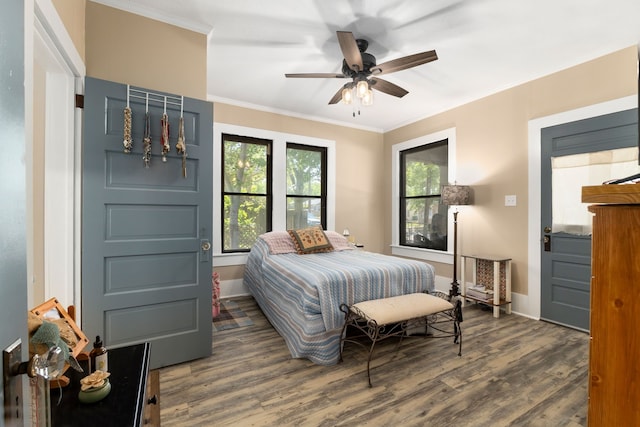 bedroom featuring crown molding, a ceiling fan, wood finished floors, and baseboards