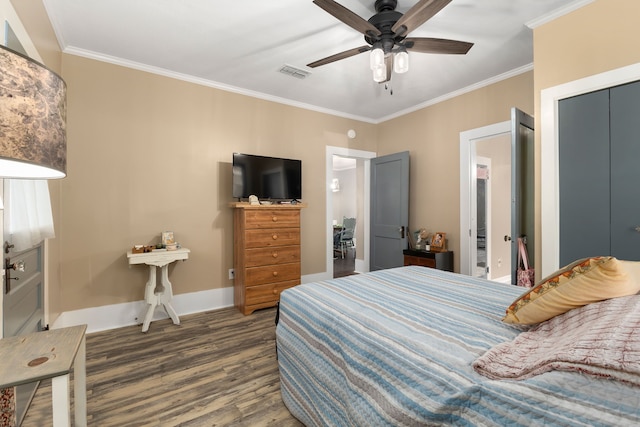 bedroom with baseboards, visible vents, wood finished floors, and crown molding