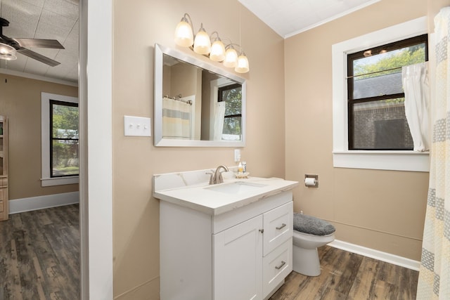 full bath with vanity, ceiling fan, toilet, crown molding, and wood finished floors
