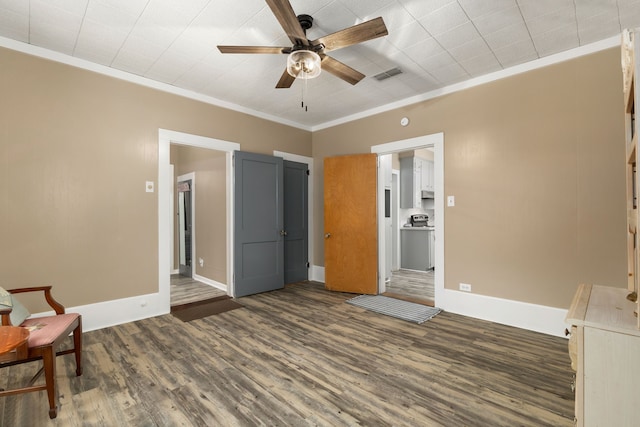 unfurnished bedroom with ornamental molding, visible vents, baseboards, and dark wood finished floors