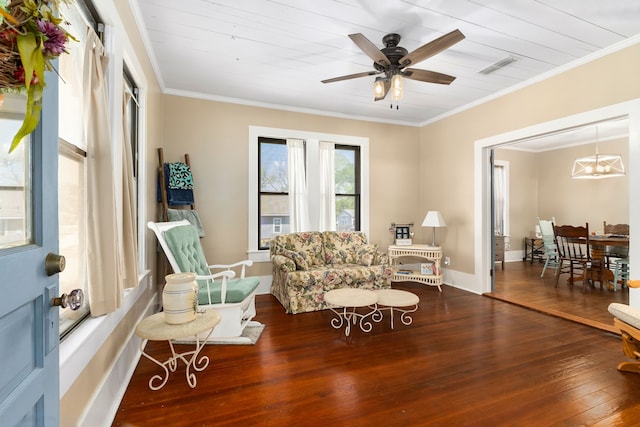 living area featuring hardwood / wood-style flooring, visible vents, baseboards, ornamental molding, and a ceiling fan