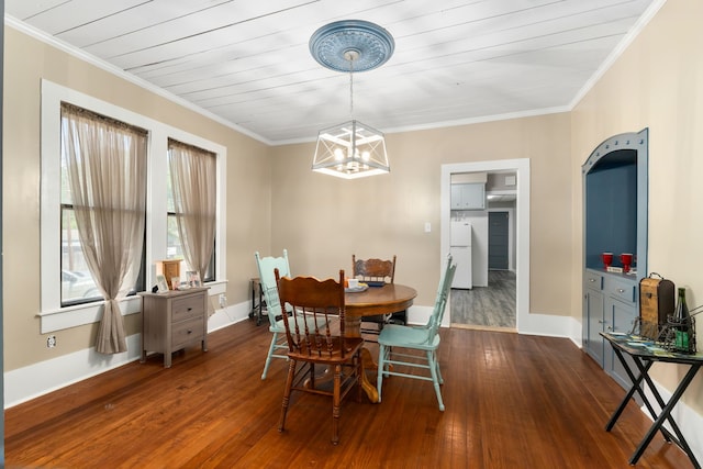 dining space featuring dark wood-type flooring, a chandelier, crown molding, and baseboards