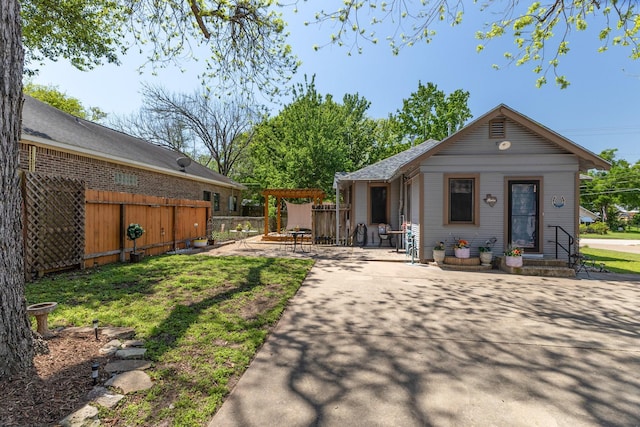 rear view of house with fence and a patio area