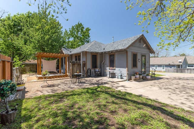 back of house featuring a patio, roof with shingles, a pergola, and fence