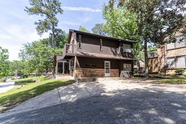 view of front of house with driveway and brick siding